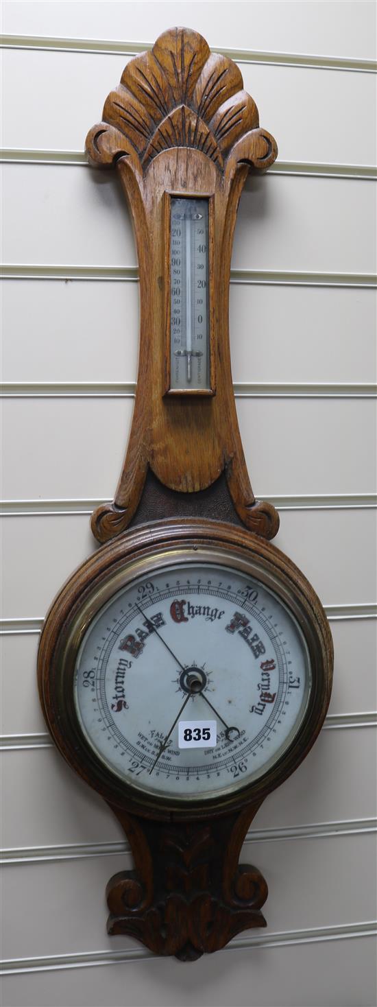 An oak aneroid barometer W.26cm